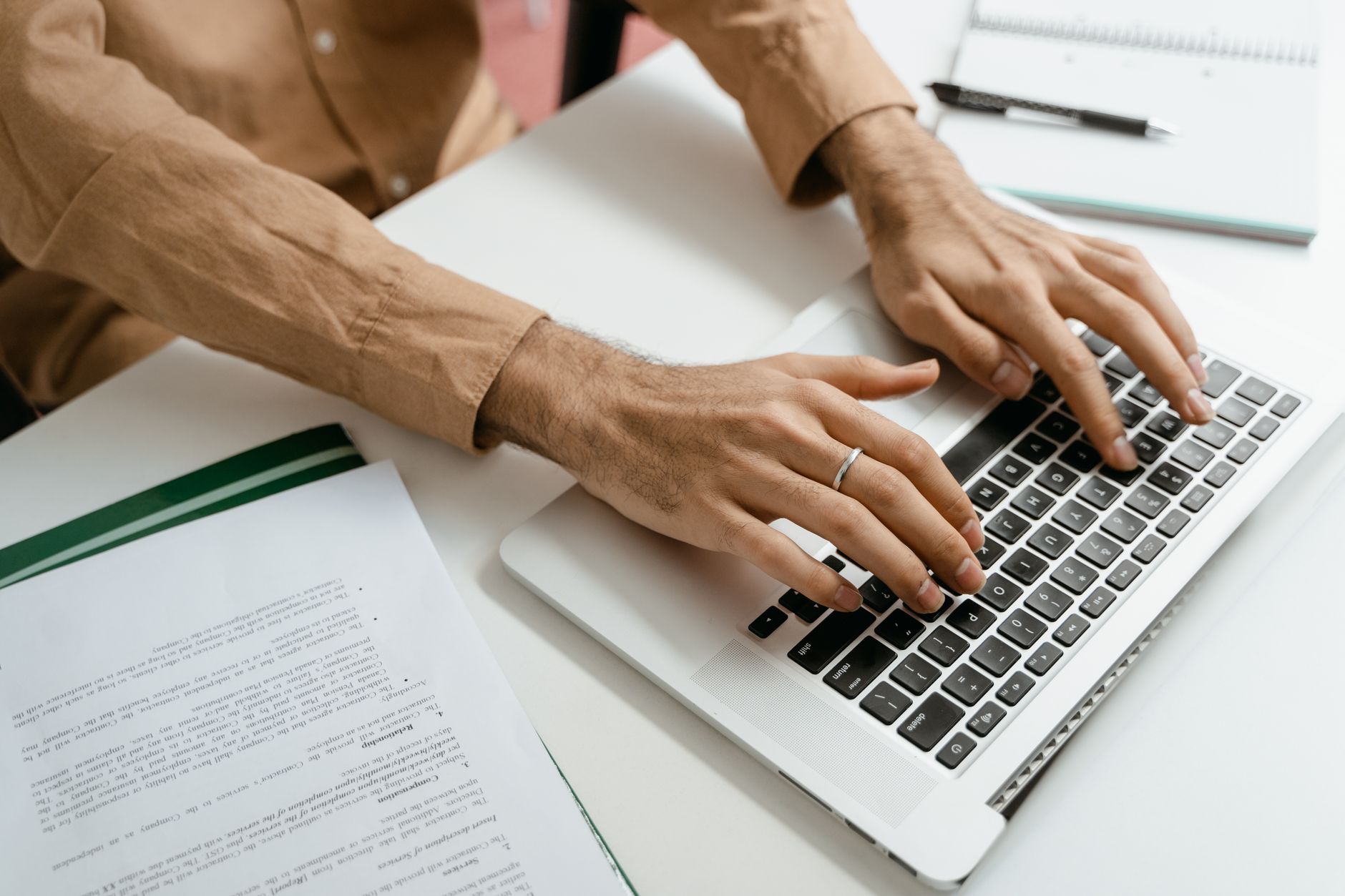 Person typing a long document on a laptop in a home office
