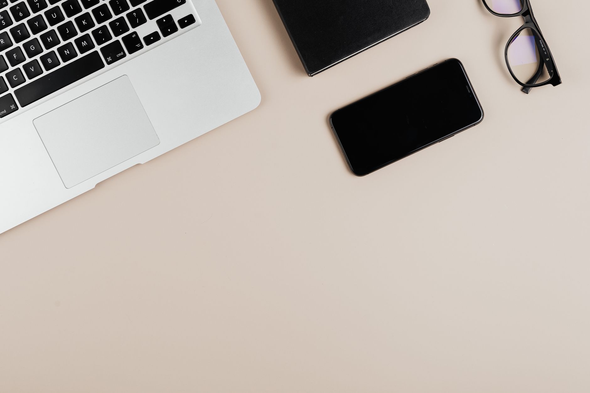 a clean desk with a single laptop and phone representing a minimal AI stack