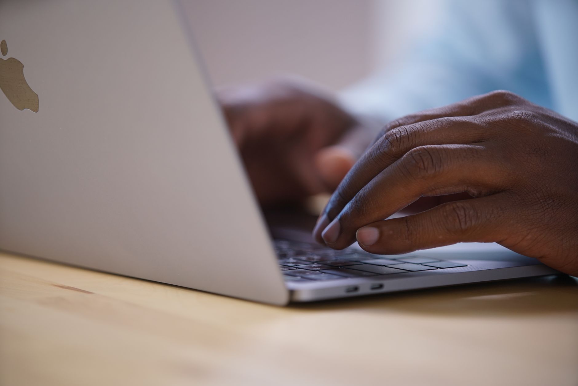 Person typing a research query into an AI search tool on a laptop at a desk