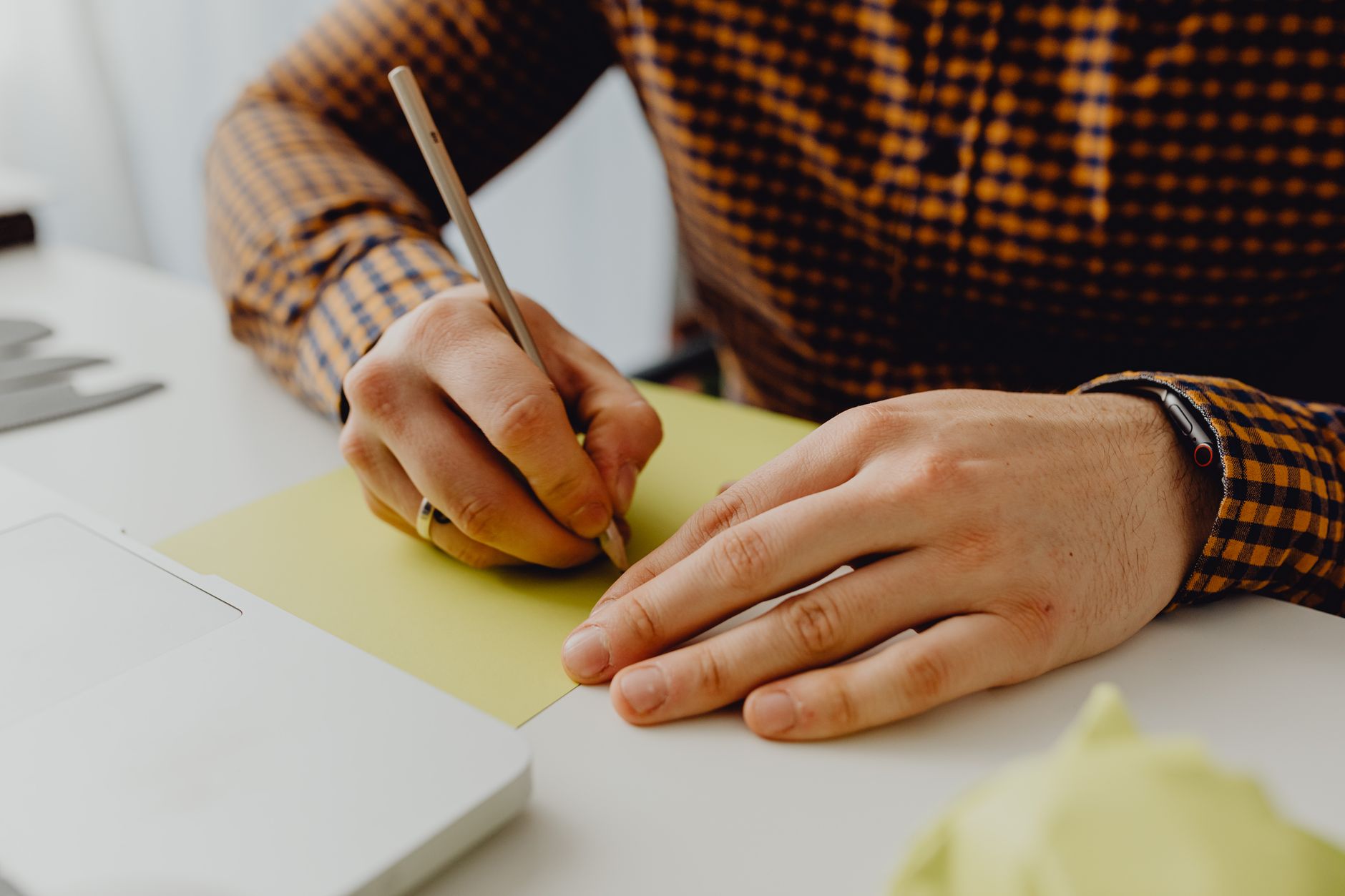 Hands crossing out items on a paper subscription list with a pen